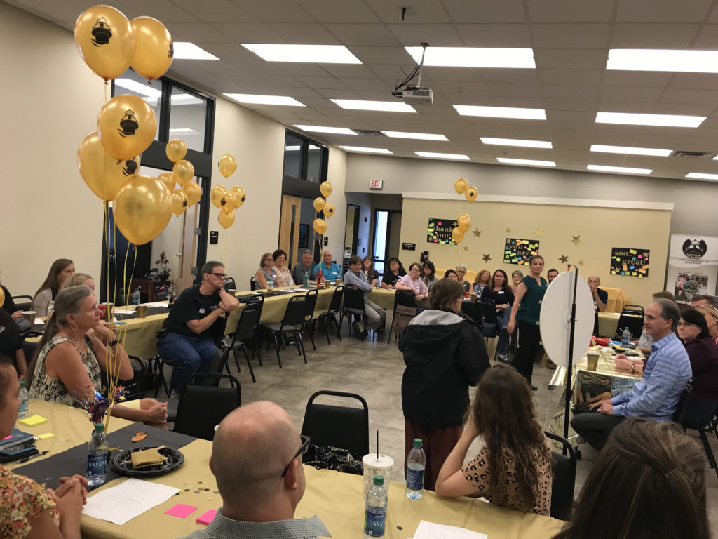 Staff participating in new branding reveal event Click to Enlarge